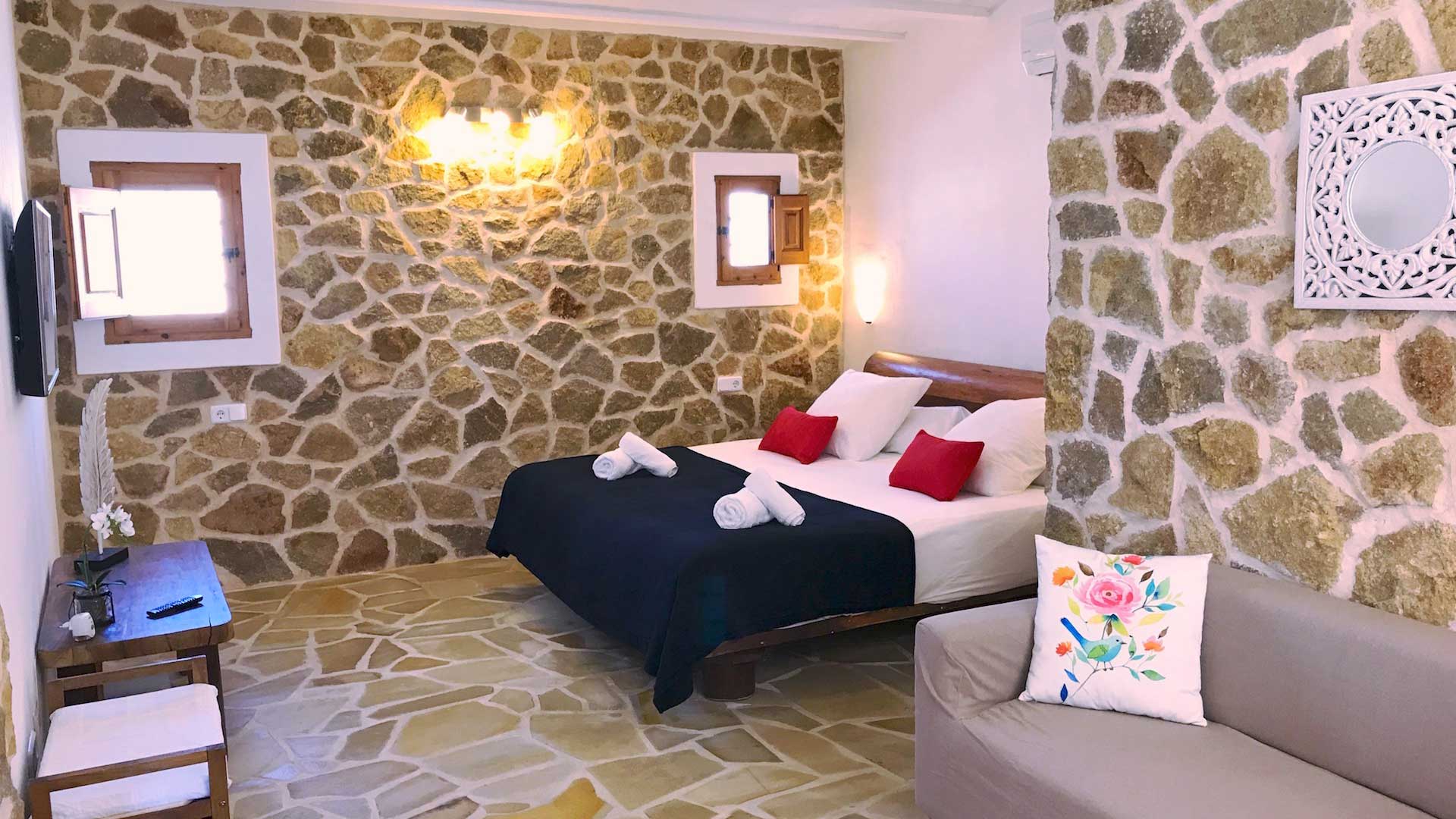 A bedroom in Villa Payesa with stone walls and a blue and white bed