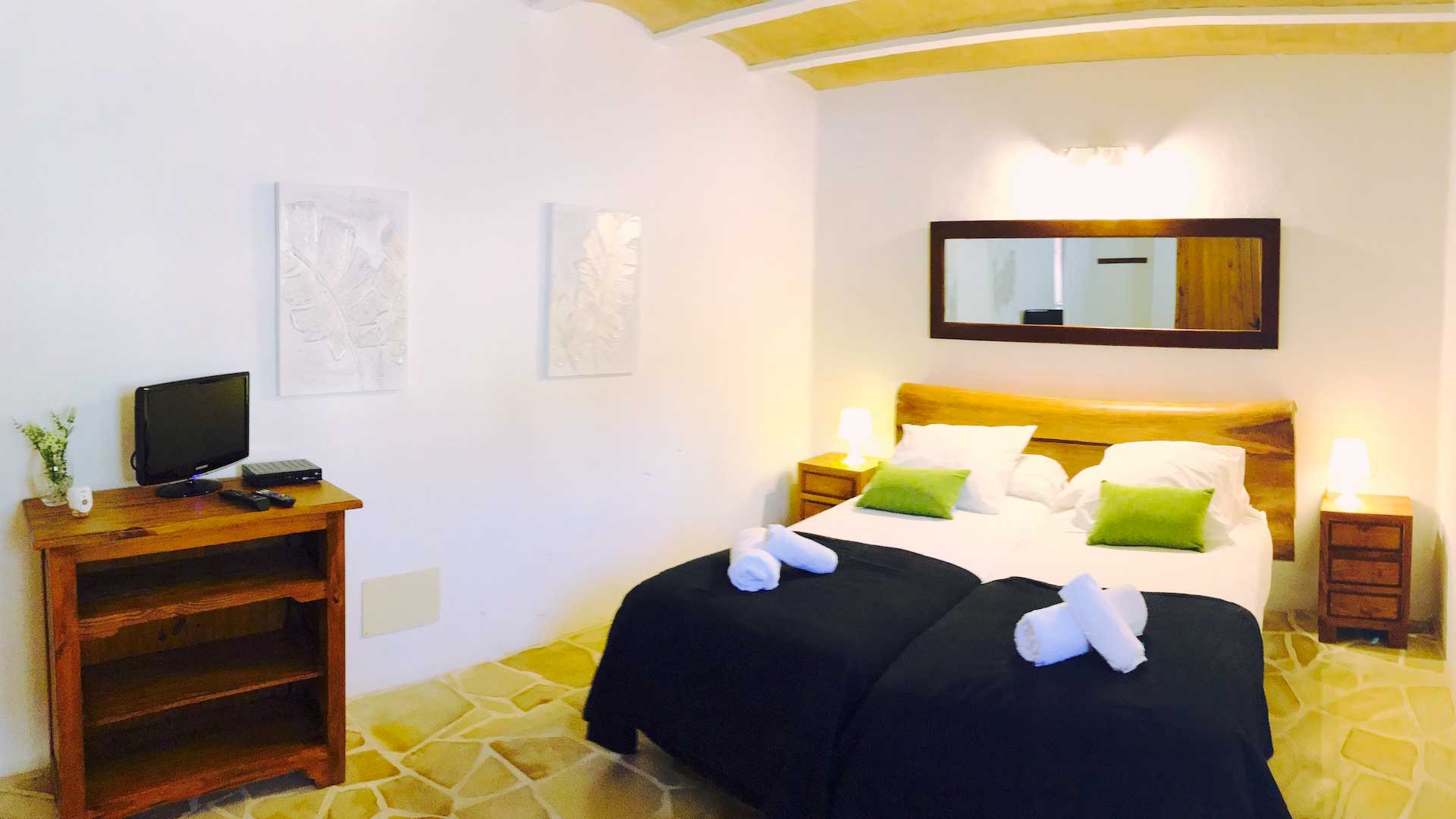 A blue and white bed with green accents in one of the bedrooms in Villa Payesa in Ibiza