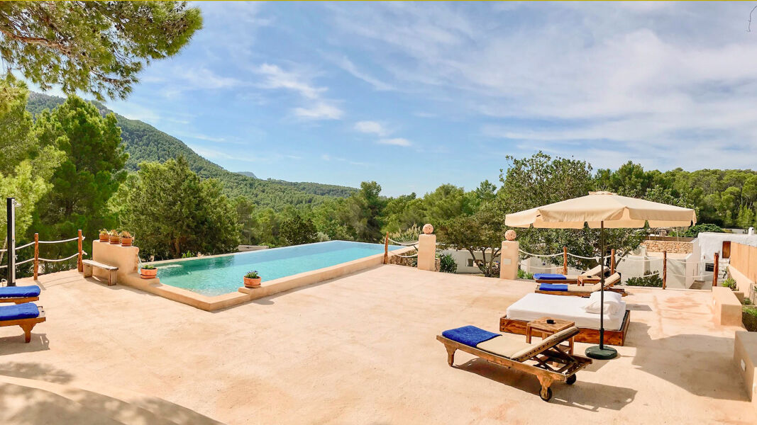 Villa Payesa's patio with it's light blue swimming pool and sunbeds and loungers to soak up the Ibiza sun