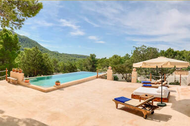Villa Payesa's patio with it's light blue swimming pool and sunbeds and loungers to soak up the Ibiza sun
