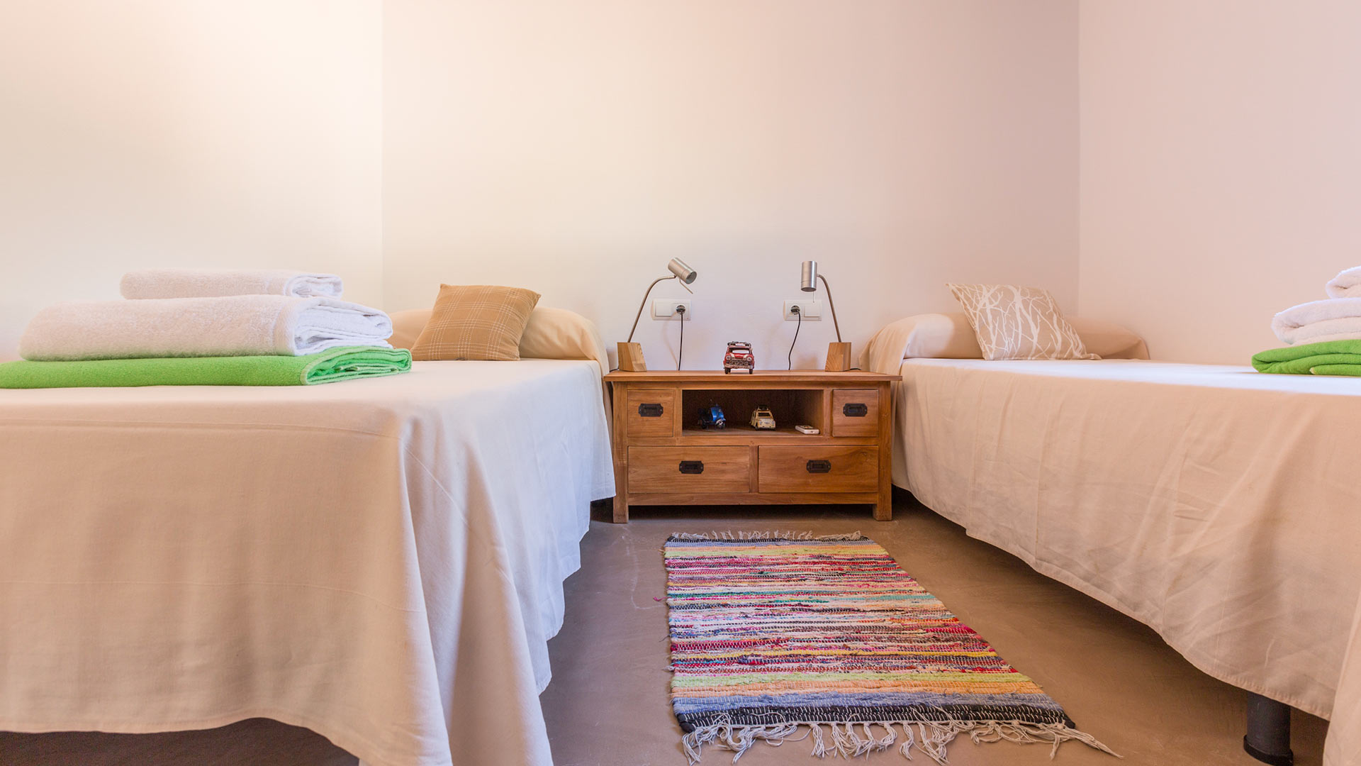 Twin bedroom at Villa Tiramar in Ibiza with a beautiful rug