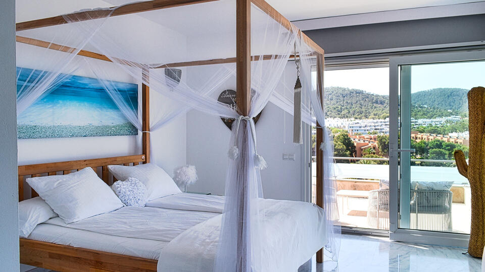 Patio doors and perfect Ibiza views from a bedroom at Villa White Beach