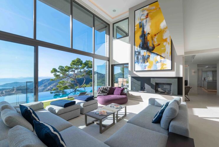 Living space of villa rental in Monaco, with large artwork displayed and views out to the infinity pool