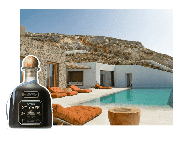 Swimming pool and lounging area at Aqua Terra Mykonos with a bottle of Patron XO Cafe overlaid.png