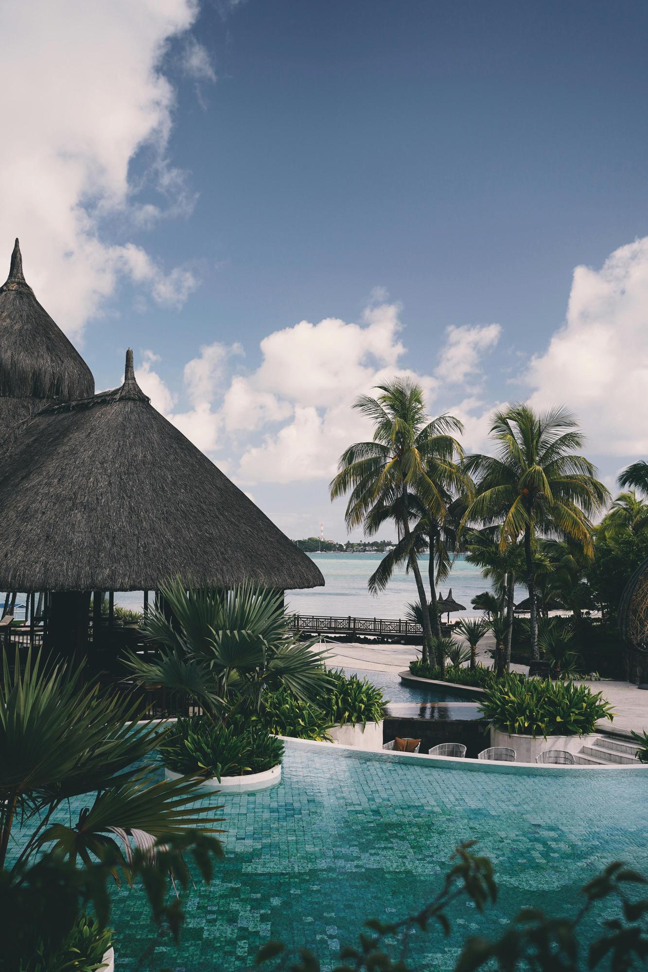 A luxury villa's pool in Mauritius with palm trees in the background