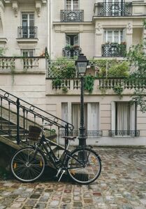 Street in Paris with a bicycle propped up against a set of stairs