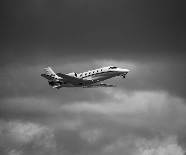 Bluemoon private jet on charter flying above the clouds