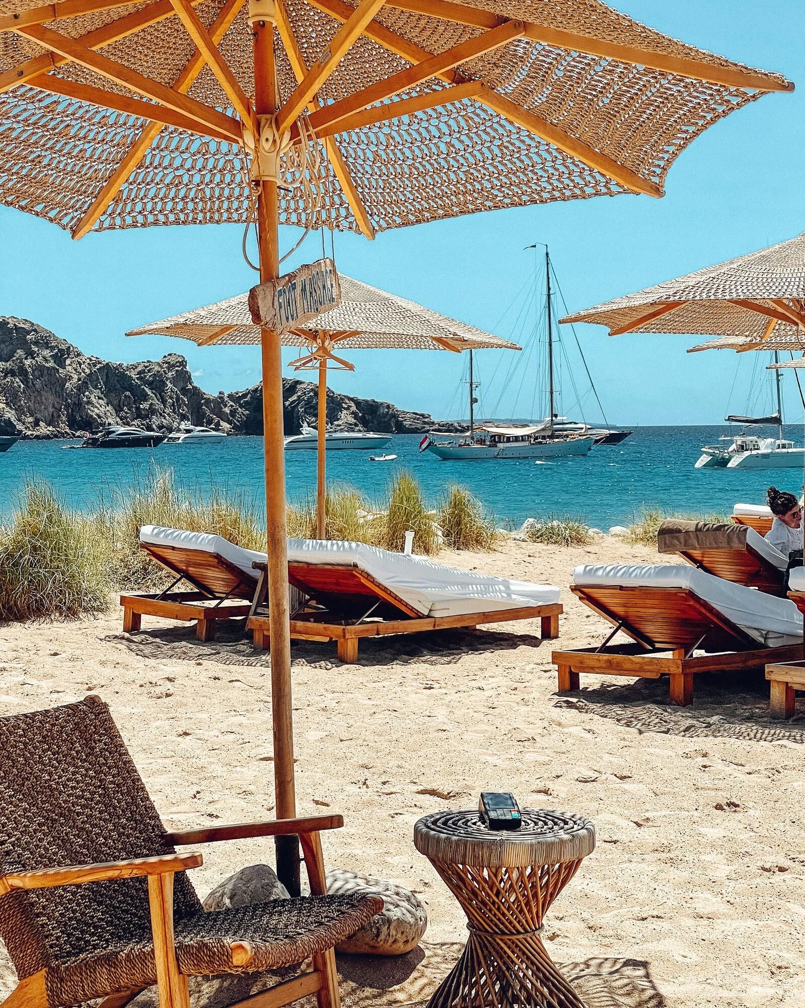 Shaded sunloungers on a beach in Ibiza with the crystal blue waters