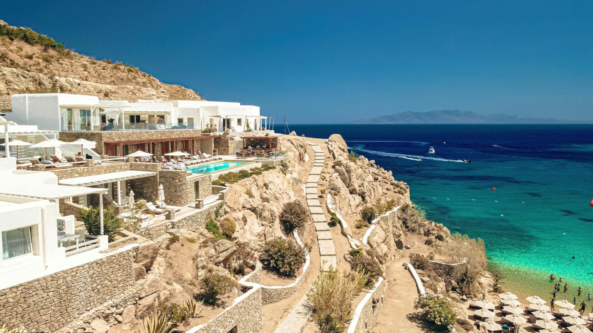 Aerial view of Mykonos luxury villa and yachts on the sea behind it