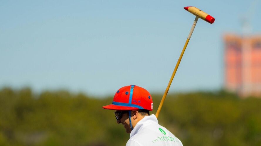 Shoulder up of a polo player with his raised polo mallet