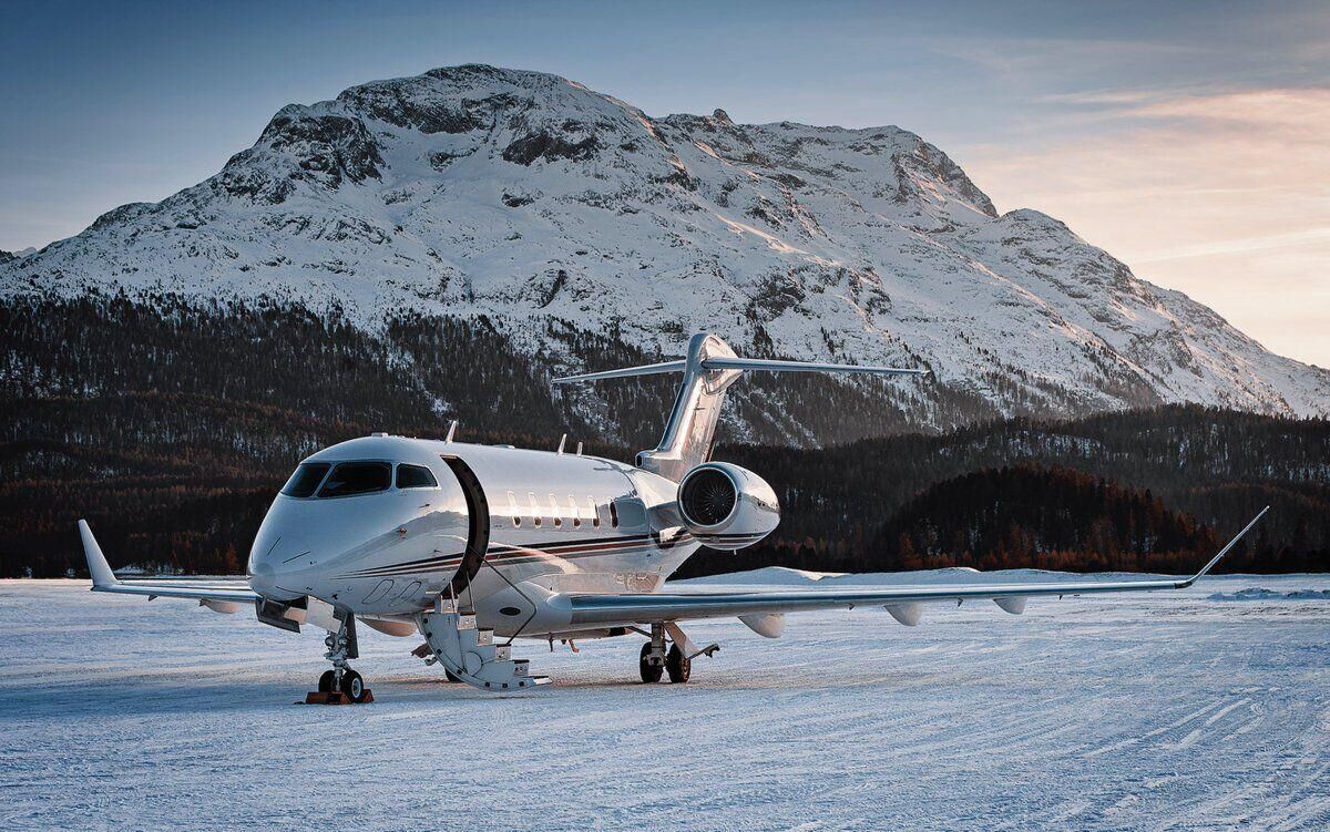 Private jet in front of snow-topped mountains