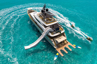 Aerial view of the yacht Halcyon with guests making waves around it with the jet ski