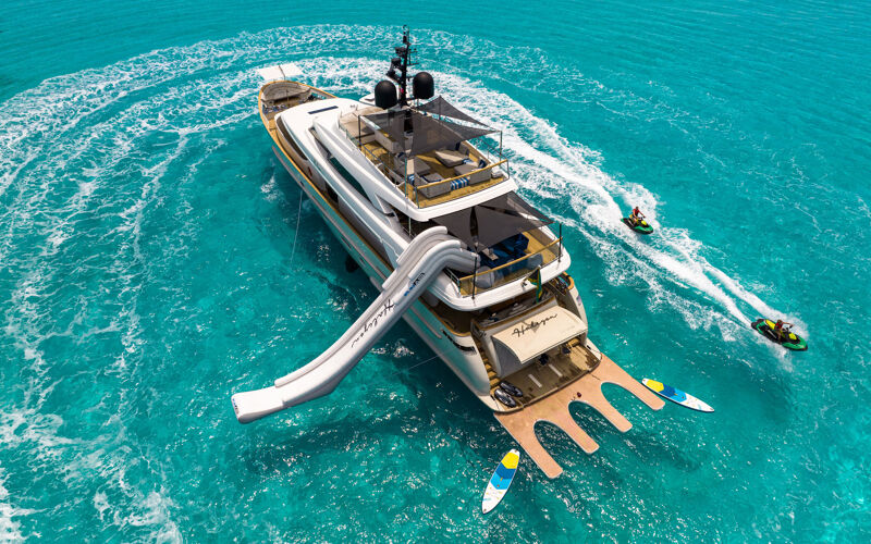 Aerial view of the yacht Halcyon with guests making waves around it with the jet ski