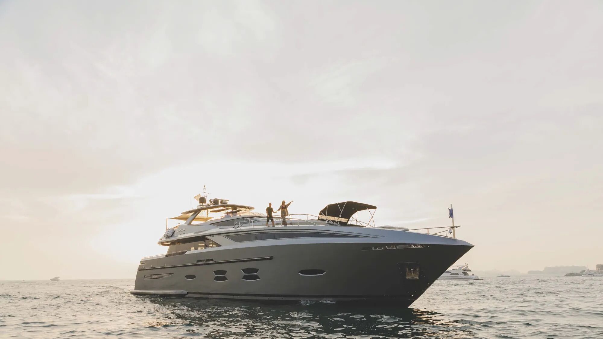 A couple on the bow of motor yacht Santorini available for charter with Bluemoon