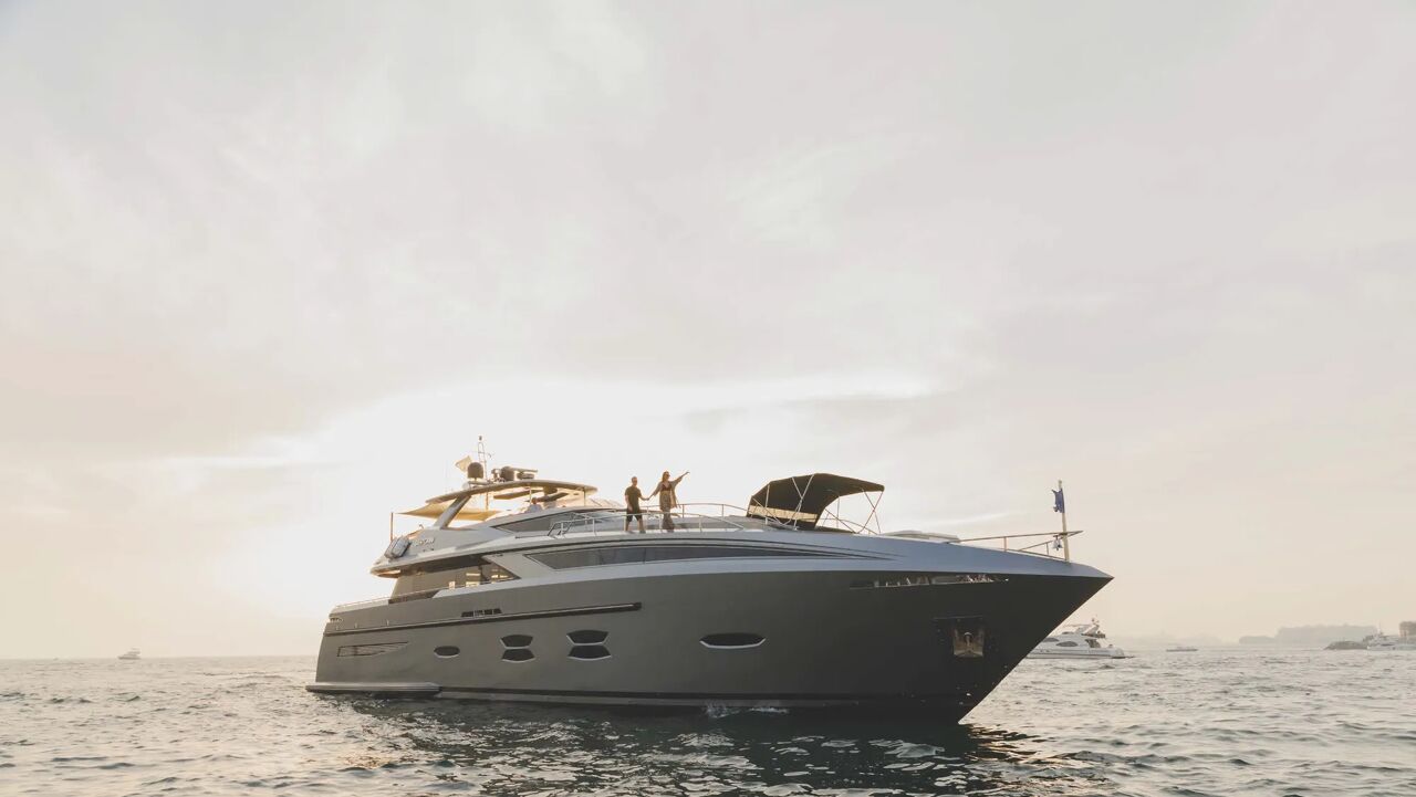 A couple on the bow of motor yacht Santorini available for charter with Bluemoon